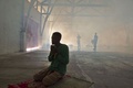 インドネシア・アチェ州東部ランサに設置された仮設の収容施設で、燻蒸消毒の煙の中で祈る救助されたバングラデシュ人（2015年5月19日撮影）。(c)AFP/ROMEO GACAD