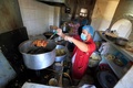 マスクを着けて調理をする男性（2020年3月23日撮影、資料写真）。(c)Mohammed HUWAIS / AFP