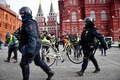 ロシア・モスクワ中心部で、拘束されたウクライナ侵攻抗議デモの参加者の自転車を運ぶ警察官（2022年3月13日撮影）。(c)AFP