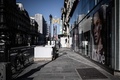 仏パリの人けのなくなった店の前を歩く人（2020年3月19日撮影）。(c)Philippe LOPEZ / AFP