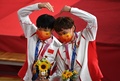 東京五輪、自転車トラック女子チームスプリントの表彰式で、毛沢東のバッジをつける中国の鮑珊菊（左）と鍾天使（2021年8月2日撮影）。(c)Greg Baker / AFP