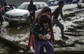 キャンプのぬかるみを歩く難民たち。(c)AFP/Bulent Kilic