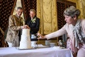 スイス・ジュネーブで行われた結婚式で、ケーキに入刀するダニエルさん（中央）とグザビエさん（左、2022年7月1日撮影）。(c)Fabrice COFFRINI / AFP