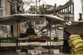 シリア北部ラッカの倒壊した建物の前で野菜や果物を売る露天商（2019年4月14日撮影）。(c)AFP / Delil Souleiman