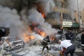 レバノン・ベイルート（Beirut）南部のハレト・フレイク（Haret Hreik）で、自動車爆弾が爆発した現場で炎を上げる車の消火に当たる消防隊員（2014年1月21日撮影）。(c)AFP