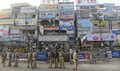 インド南部ハイデラバード（Hyderabad）のディルスクナガール（Dilsukh Nagar）地区で前日に起きた爆弾攻撃の現場の前に立つ警察官ら（2013年2月22日撮影）。(c)AFP/Indranil MUKHERJEE