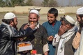 パキスタン北西部ペシャワールの難民キャンプで、アフガニスタンで「暴力削減措置期間」の合意がされたことを祝福しお菓子を配る難民（2020年2月22日撮影）。(c)Abdul MAJEED / AFP
