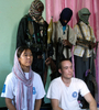 ソマリアの首都モガディシオ（Mogadishu）で、武装集団の監視下で報道陣の取材に応じる人質の国際NPO「世界の医療団（Medecins du Monde）」の日本人医師（前列左）とオランダ人看護士（同右、2008年10月10日撮影）。(c)AFP