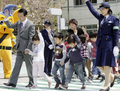 「春の全国交通安全運動中央大会」で小学生と手をつないで横断歩道を渡る麻生太郎（Taro Aso）首相（2004年4月13日撮影）。(c)AFP/Yoshikazu TSUNO