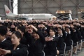 都内の羽田空港で、日本航空（JAL）グループの入社式を前にストレッチをする新入社員ら（2016年4月1日撮影）。(c)AFP/KAZUHIRO NOGI