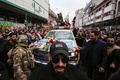 イラクの首都バグダッドで、殺害されたイラン革命防衛隊のガセム・ソレイマニ司令官のひつぎを運ぶ車の周囲に集まった人々（2020年1月4日撮影）。(c)AFP/SABAH ARAR