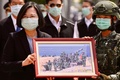 台湾南部の台南にある軍基地を訪れ、兵士から記念写真を受け取る蔡英文総統（左、2020年4月9日撮影）。(c)Sam Yeh / AFP