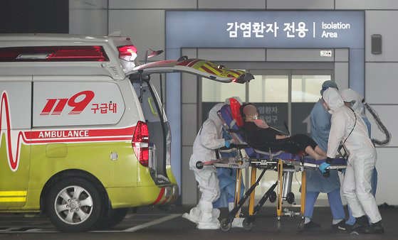 新型コロナ感染者を運ぶ救急隊員(c)news1