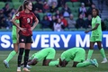 サッカー女子W杯オーストラリア・ニュージーランド大会、グループB、ナイジェリア対カナダ。カナダのジョーディン・ハイテマ（左）の近くで引き分けを喜ぶナイジェリアの選手（2023年7月21日撮影）。(c)WILLIAM WEST / AFP