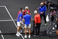 男子テニスの欧州チームとワールドチームの対抗戦、レーバー・カップ初日。ネットの間を抜けたボールをめぐり、主審と言葉をかわす欧州チームのロジャー・フェデラー（左手前）/ラファエル・ナダル（中央手前）組ら（2022年9月23日撮影）。(c)Glyn KIRK / AFP