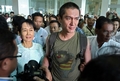 ミャンマー・ヤンゴン（Yangon）の空港で約10年ぶりに再会したアウン・サン・スー・チー（Aung San Suu Kyi）さん（左）と次男のキム・アリス（Kim Aris）氏(中央、2010年11月23日撮影）。(c)AFP/Soe Than WIN