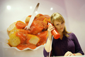 ドイツ・ベルリン（Berlin）で、ソーセージにケチャップとカレー味のソースをかけた名物料理「カリーブルスト（Currywurst）」の調理法と歴史を紹介する博物館「ドイツ・カリーブルスト博物館（German Currywurst Museum）」が、15日にオープンする。写真は、ケチャップ容器をかたどった受話機で、カリーブルストの説明を聞く女性（2009年8月13日撮影）。(c)AFP/DDP/MICHAEL GOTTSCHALK
