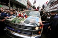 イラクの首都バグダッドで、殺害されたイラン革命防衛隊のガセム・ソレイマニ司令官のひつぎを運ぶ車の周囲に集まった人々（2020年1月4日撮影）。(c)AFP/SABAH ARAR