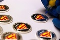 世界で最も有名なスーパーヒーロー「スーパーマン（Superman）」の誕生75周年を祝う記念硬貨を発行すると、王立カナダ造幣局（The Royal Canadian Mint）が9日、発表した。

発行される記念硬貨は全部で7種類。金、銀、白銅製で、額面は50セントから75ドル。販売価格は、白銅貨が29.75カナダドル（約2900円）で、スーパーマンの絵がカラーで刻まれた14金の金貨は750カナダドル（約7万2000円）。この金貨の発行枚数はわずか2000枚という。

トロント（Toronto）で記念硬貨の発行を発表したクリス・アレクサンダー（Chris Alexander）市民権・移民・多文化主義相は、「スーパーマンの漫画を読んで育った若い世代は、物語の裏側にある部分を完全に理解していないかもしれないが、我々の政府はスーパーマンが具現化したカナダの歴史と遺産と価値と強みを称賛したいと思う」と話した。

スーパーマンは1938年、カナダ人のジョー・シャスター（Joe Shuster）氏と米国人のジェリー・シーゲル（Jerry Siegel）氏によって発表された。

写真は色づけされる硬貨（2013年9月9日公開）。(c)AFP/ROYAL CANADIAN MINT