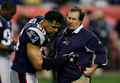 試合前にビル・ベリチック（%%Bill Belichick%%）ヘッドコーチの指示を仰ぐペイトリオッツのLBジュニア・セアウ（%%Junior Seau%%、左）。(c)AFP/Getty Images/Streeter Lecka
