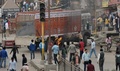 インド北部ハリヤナ州ロータクで、大規模な集会中に起きた対立カースト集団の衝突を受けてデモ隊が暴徒化する中、火がつけられたトラックのそばに立つデモ参加者（2016年2月19日撮影）。(c)AFP