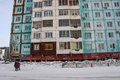 ロシアのシベリア東部ヤクーツクで、ひびが入ったアパートの前を歩く人（2018年11月26日撮影）。(c)Mladen ANTONOV / AFP