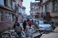 トルコ南部ハタイ県で、地震の被害を受けた地域を歩く人々（2023年2月7日撮影）。(c)BULENT KILIC / AFP