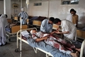 パキスタン・ペシャワル（Peshawar）北方のチャルサダ（Charsadda）地区で起きた2件の爆弾攻撃で負傷した男性を治療する医療関係者（2011年5月13日撮影）。(c)AFP/HASHAM AHMED