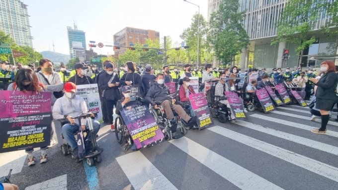 16日午前8時ごろ、大統領執務室近くでデモをする全国障害者差別撤廃連帯のメンバーら(c)MONEYTODAY