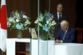 安倍晋三元首相の死去を受け、米首都ワシントンの日本大使公邸を訪れ、冨田浩司大使が見守る中、弔問者芳名録に記帳するジョー・バイデン大統領（2022年7月8日撮影）。(c)SAMUEL CORUM / AFP