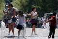 メキシコ・ハリスコ州グアダラハラで、水を浴びて涼む子どもたち（2024年5月23日撮影）。(c)ULISES RUIZ / AFP