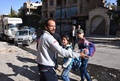 シリア・アレッポ西部で政府が支配するフルガン地区で、学校がロケット弾攻撃を受けたとして子どもたちを避難させる男性（2016年11月20日撮影）。(c)AFP/GEORGE OURFALIAN