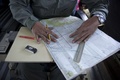 消息を絶ったマレーシア航空（Malaysia Airlines）機の捜索に参加し、マラッカ海峡（Strait of Malacca）上空を飛行するマレーシア空軍機内で地図を使って作業するマレーシア空軍の航法士（2014年3月14日撮影）。(c)AFP/MOHD RASFAN