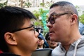 香港立法会（議会）の補欠選挙で、民主派の活動家、黄之鋒（ジョシュア・ウォン）氏（左）に詰め寄る男性（2018年3月11日撮影）。(c)AFP PHOTO / ANTHONY WALLACE