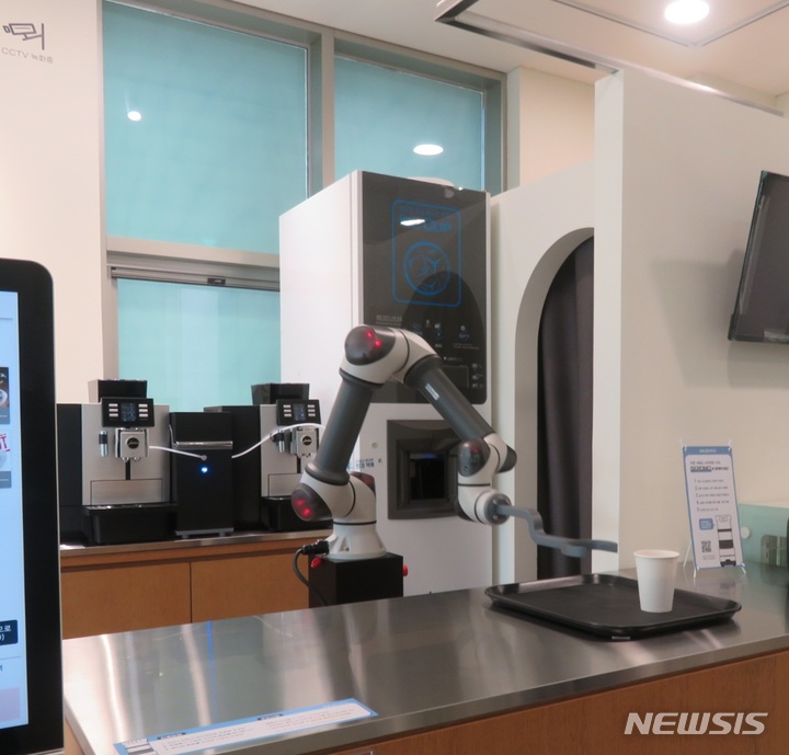 ロボットカフェで運営中のロボットがアイスアメリカーノを製造して持ってきている(c)NEWSIS