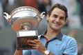 全仏オープンテニス2009（%%French Open 2009%%）男子シングルス決勝。大会第2シードのロジャー・フェデラー（%%Roger Federer%%、スイス）は、大会第23シードのロビン・ソデルリング（%%Robin Soderling%%、スウェーデン）と対戦。フェデラーは6-1、7-6、6-4で全仏初優勝を果たし、ピート・サンプラス（%%Pete Sampras%%、米国）氏の持つグランドスラム最多優勝記録（14勝）に並ぶと同時に、史上6人目の生涯グランドスラム（4大大会全制覇）を達成した。写真はトロフィーを手に笑顔を見せるロジャー・フェデラー。（2009年6月7日撮影）(c)AFP/BERTRAND GUAY