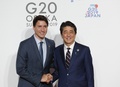 大阪で開催された20か国・地域（G20）首脳会議（サミット）で、カナダのジャスティン・トルドー首相を歓迎する安倍晋三元首相（2019年6月28日撮影）。(c)KIM KYUNG-HOON / POOL / AFP