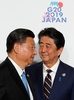大阪で開催中の20か国・地域（G20）首脳会議の歓迎行事で、中国の習近平国家主席（左）を迎える安倍晋三首相（右、2019年6月28日撮影）。(c)KIM KYUNG-HOON / POOL / AFP