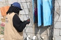 イエメン首都サヌア北西のアブスにある太陽光発電所でケーブルを点検する女性（2021年3月9日撮影）。(c)AFP
