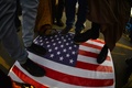 米軍による武装組織「神の党旅団（カタイブ・ヒズボラ）」の拠点空爆に抗議し、米国旗を踏みつけるイラク市民ら（2019年12月30日撮影）。(c)Haidar HAMDANI / AFP