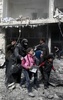 シリア首都ダマスカス近郊の東グータで行われた政府軍の爆撃後に避難する女性と子どもたち（2018年2月19日撮影）。(c)AFP PHOTO / ABDULMONAM EASSA