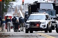 銃乱射事件が発生した米ペンシルベニア州ピッツバーグのシナゴーグ「ツリー・オブ・ライフ」付近の道路を検分する連邦捜査局（FBI）の捜査員ら（2018年10月28日撮影）。(c)Brendan Smialowski / AFP