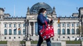 ドイツの首都ベルリンで、マスクをして議会前を歩く女性（2020年4月15日撮影）。(c)John MACDOUGALL / AFP