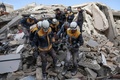 シリア北西部のトルコ国境沿いにある村で、地震により建物が倒壊した現から犠牲者の遺体を搬送する救助ボランティア団体「ホワイト・ヘルメット」の隊員（2023年2月7日撮影）。(c)Omar HAJ KADOUR / AFP