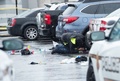 1人が死亡、2人が負傷した銃撃事件が発生した米メリーランド州ベセスダのショッピングモール「ウエストフィールド・モンゴメリー」の駐車場で車の下をのぞき込み、事件の証拠を探す警察官（2016年5月6日撮影）。(c)AFP/NICHOLAS KAMM