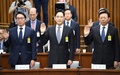 韓国・朴槿恵（パク・クネ）大統領の親友による国政介入疑惑に絡み、国会の聴聞会に呼ばれて宣誓する（左から）SKグループ会長の崔泰源（チェ・テウォン）氏、サムスン電子副会長の李在鎔（イ・ジェヨン）氏、ロッテグループ会長の辛東彬（シン・ドンビン、重光昭夫）氏（2016年12月6日撮影）。(c)AFP/JUNG YEON-JE