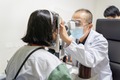 李福新さん（左）を診察する広州市の眼科専門医（2020年8月14日撮影）。(c)Xinhua News