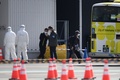 クルーズ船「ダイヤモンド・プリンセス」から下船した乗客（右）。横浜港の大黒ふ頭にて（2020年2月19日撮影）。(c)CHARLY TRIBALLEAU / AFP