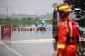 中国東部・江蘇省鎮江で、長江沿いの堤防を見回る消防署員（2020年7月20日撮影）。(c)STR / AFP