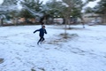 イラクの聖地カルバラで、雪の積もった公園内を走る少年（2020年2月11日撮影）。(c)Mohammed SAWAF / AFP